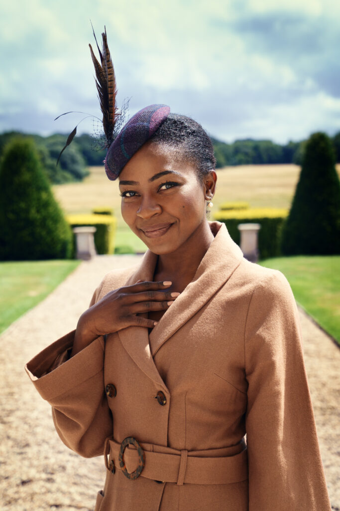 beautiful young woman in camel coloured coat on a country estate