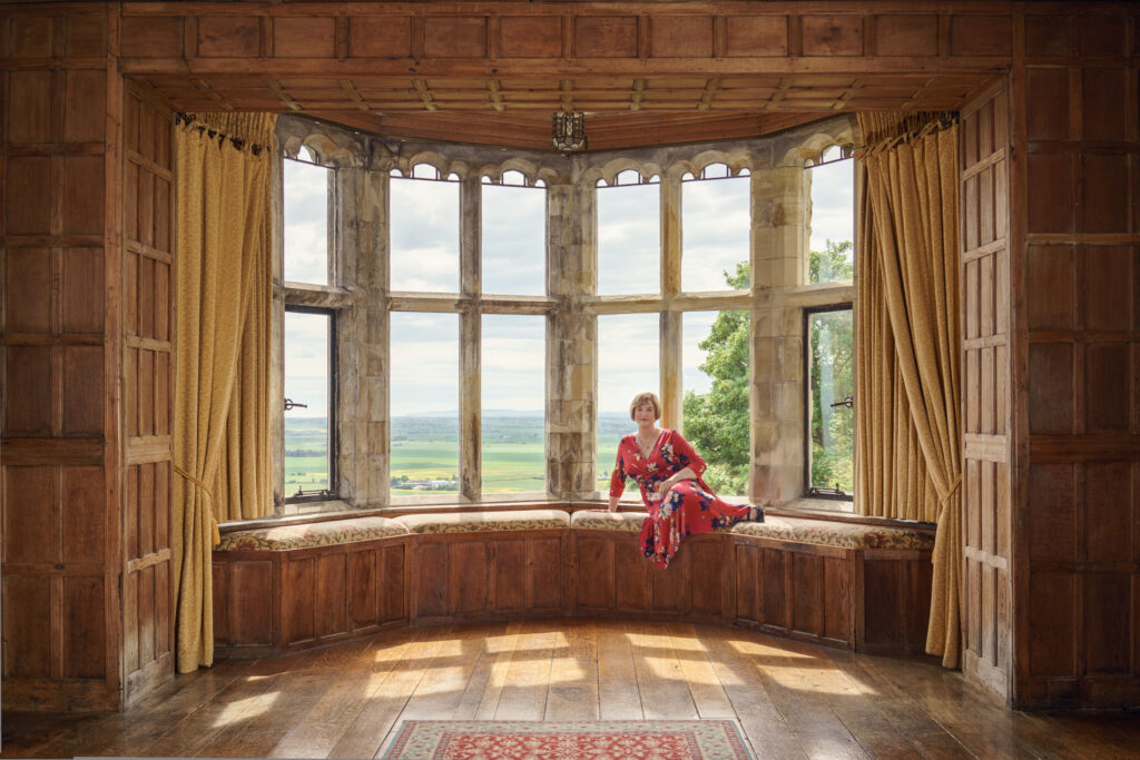 woman sitting in the window seat of a castle