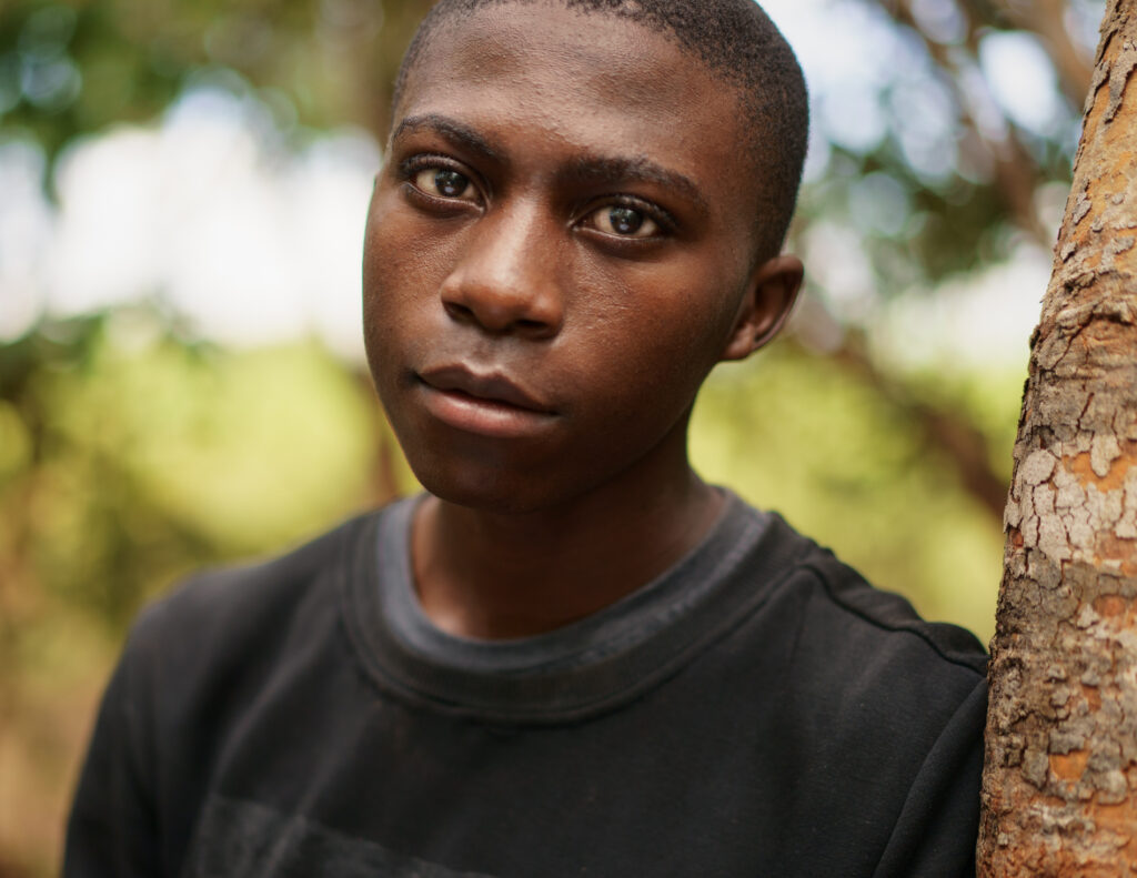 young man in the woods, direct gaze