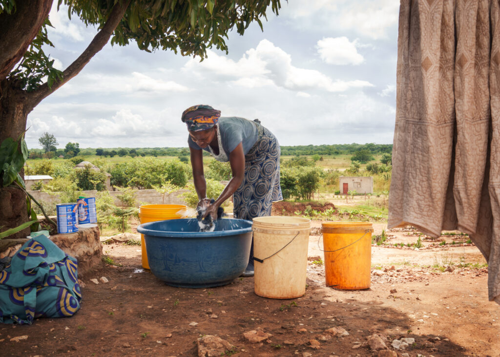Zambian woman hand washing clothes and sheets