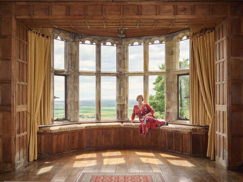 woman sitting in large castle window seat